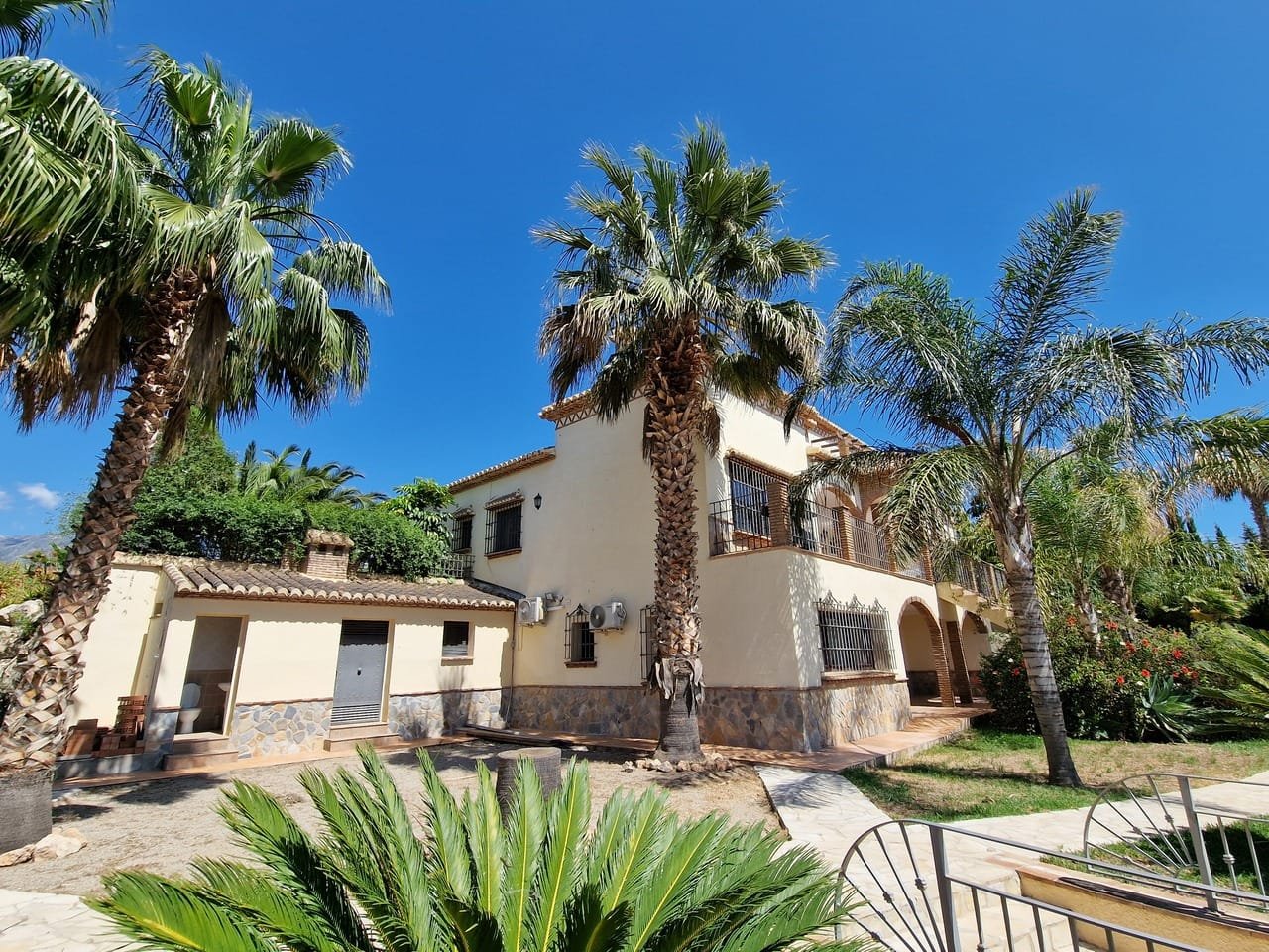 Cream two-storey villa framed by tall palms