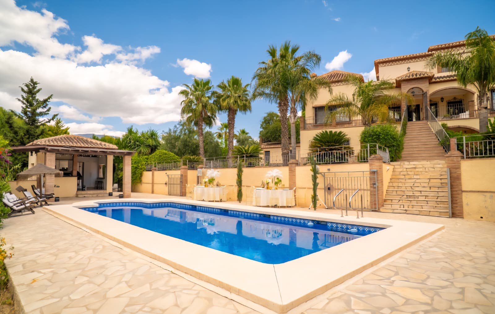Terraced villa with stone staircase leading down to a pool and styled reception tables